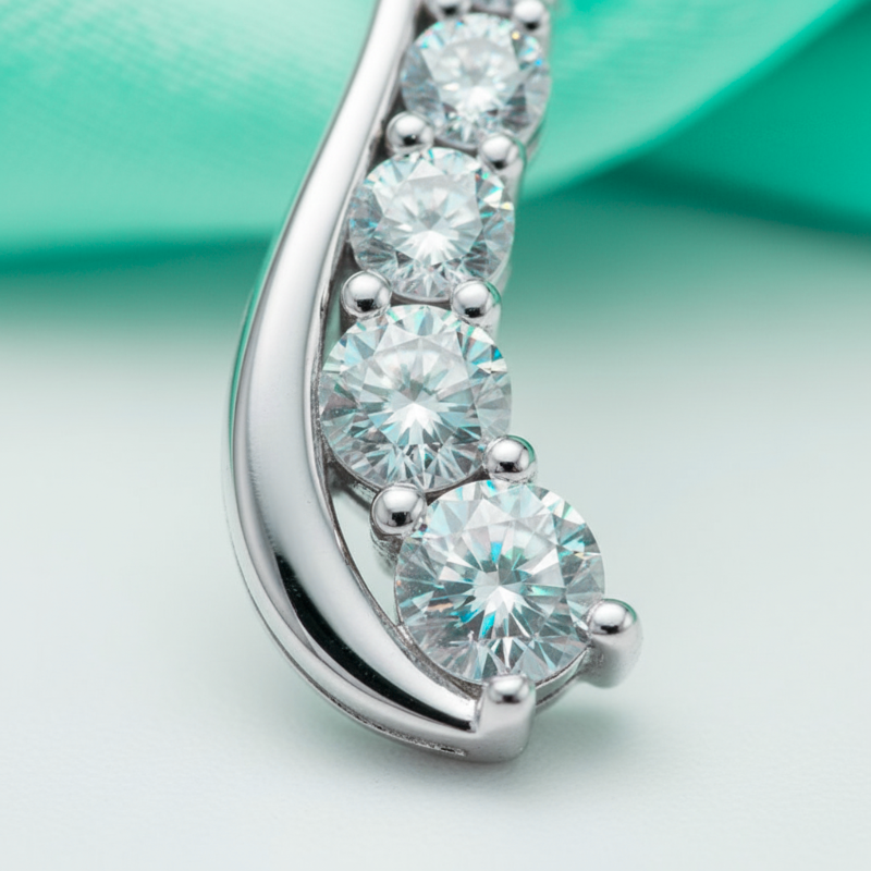 Silver earring with clear gemstones on a light green background